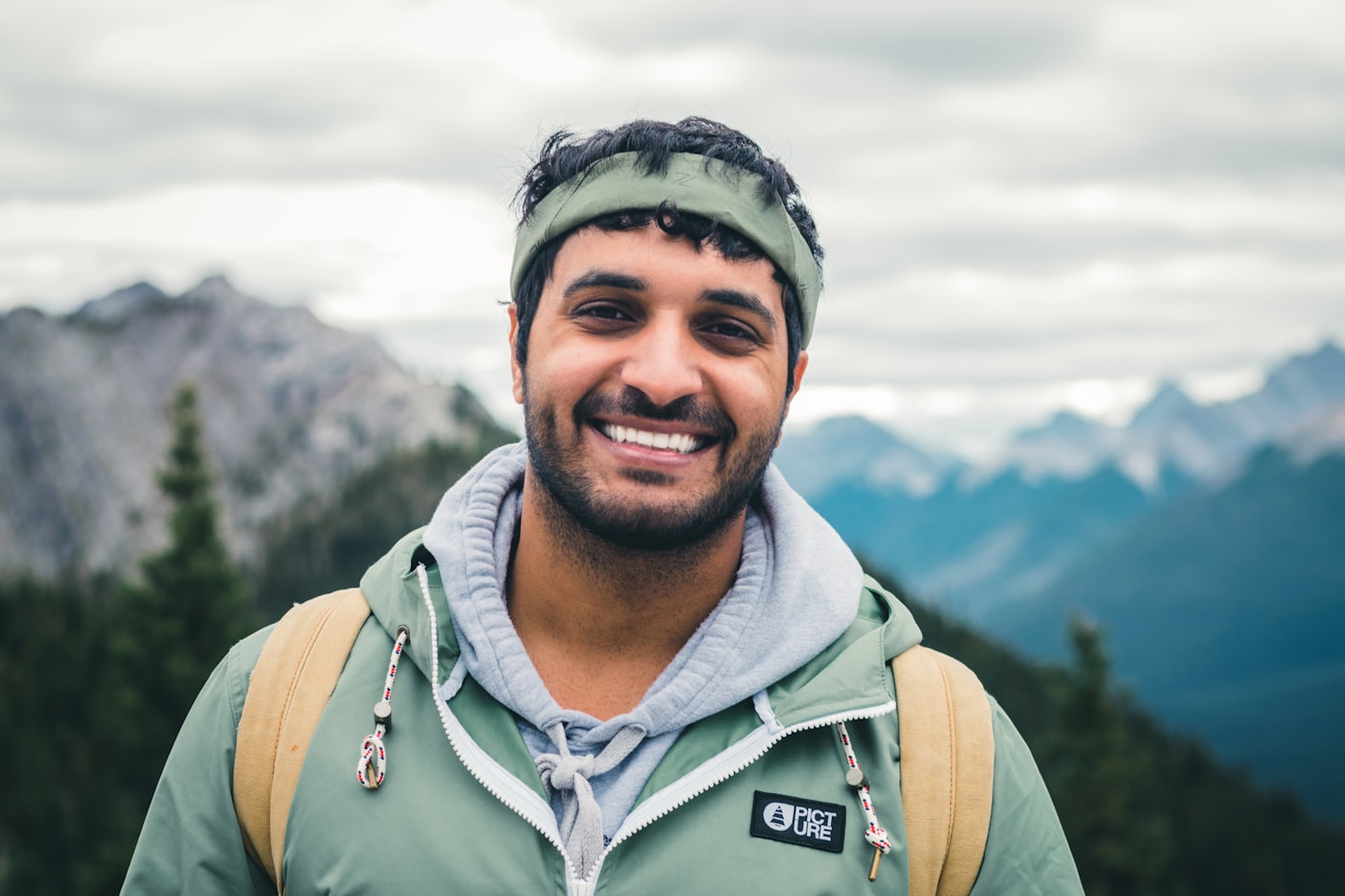 Man smiling outdoors while hiking in the mountains