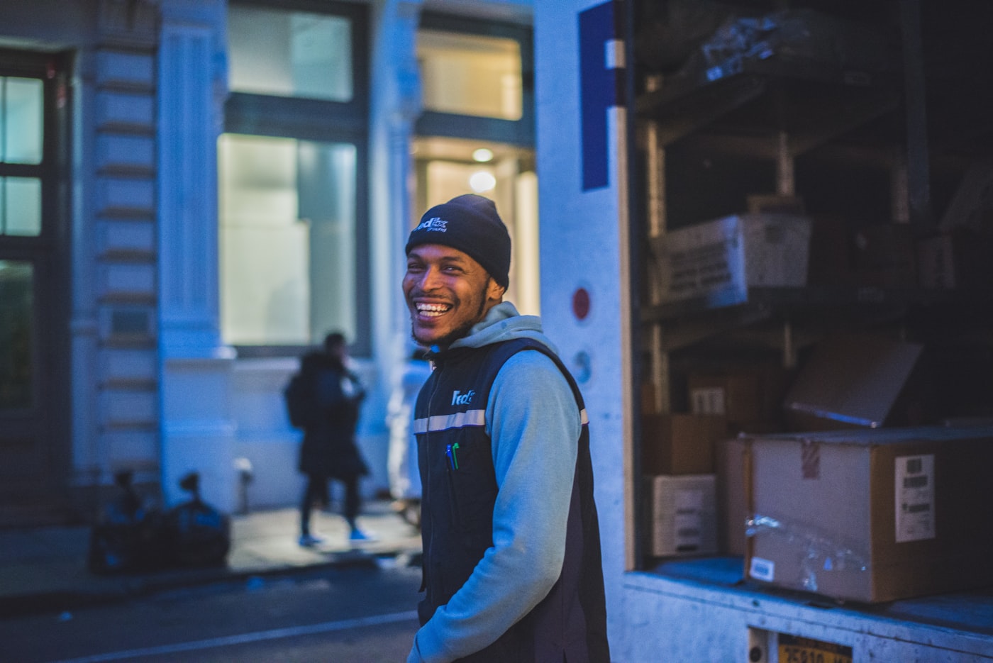 Smiling delivery driver standing by his van full of packages