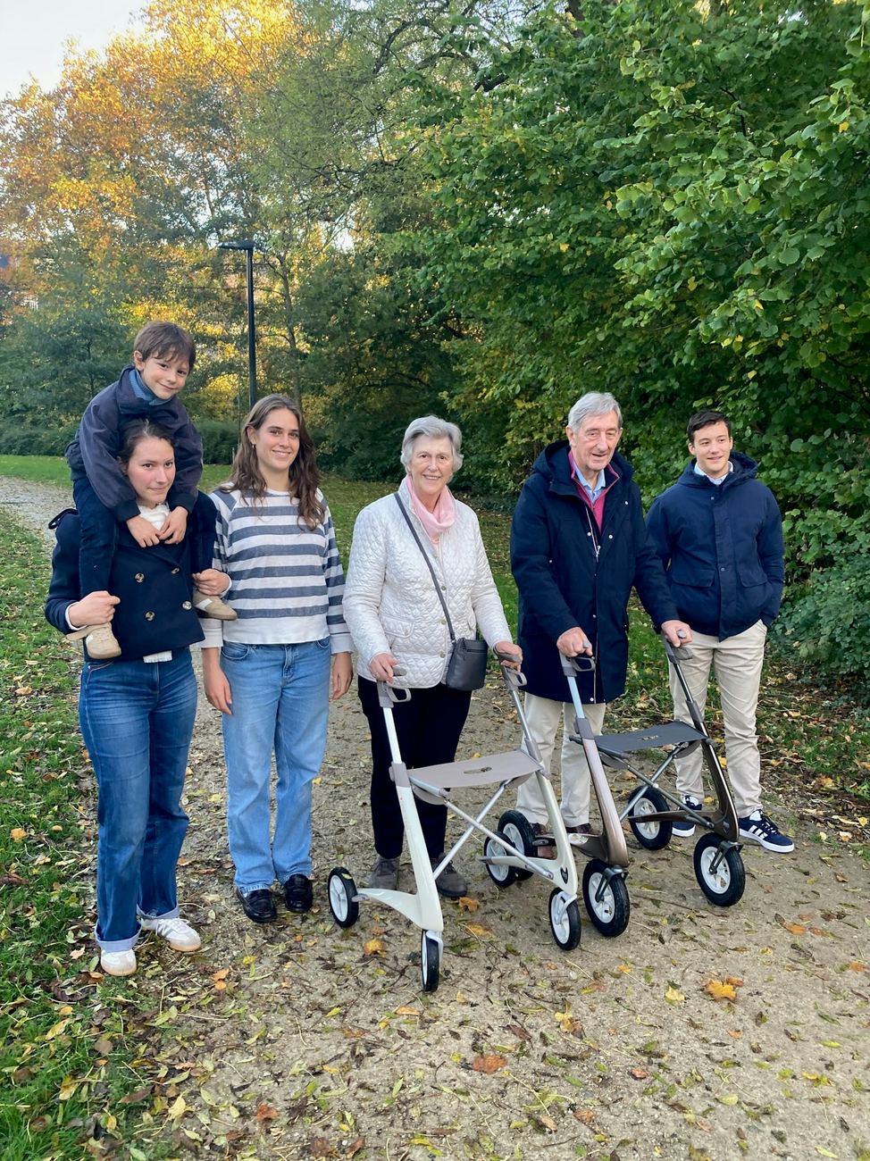 A multi-generational family walking together in a park